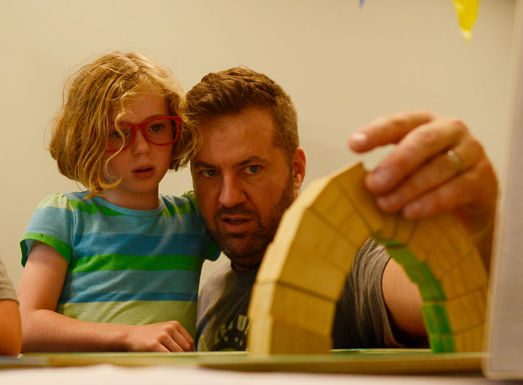 Emma Grace Webel, 7, and her father Corey Webel make an arch